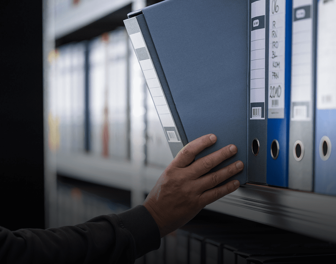 Hand selecting blue binder from shelf
