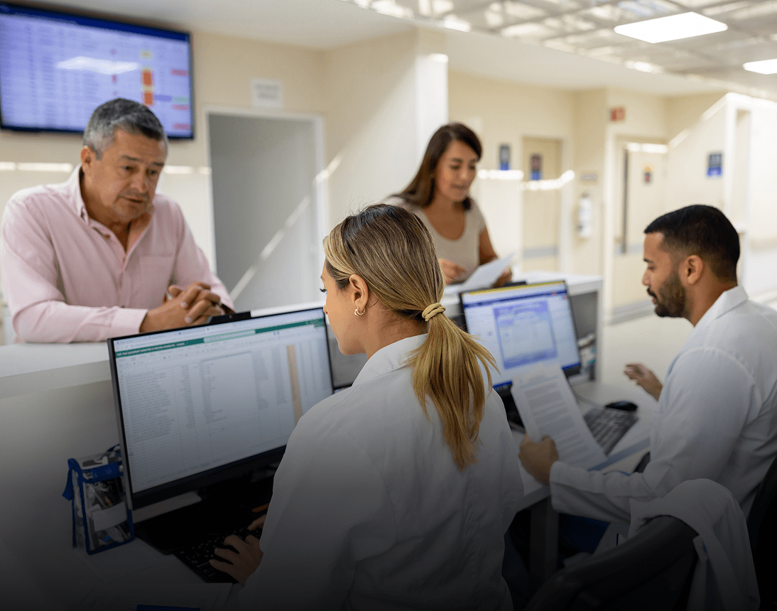 Medical staff assisting patients at desk