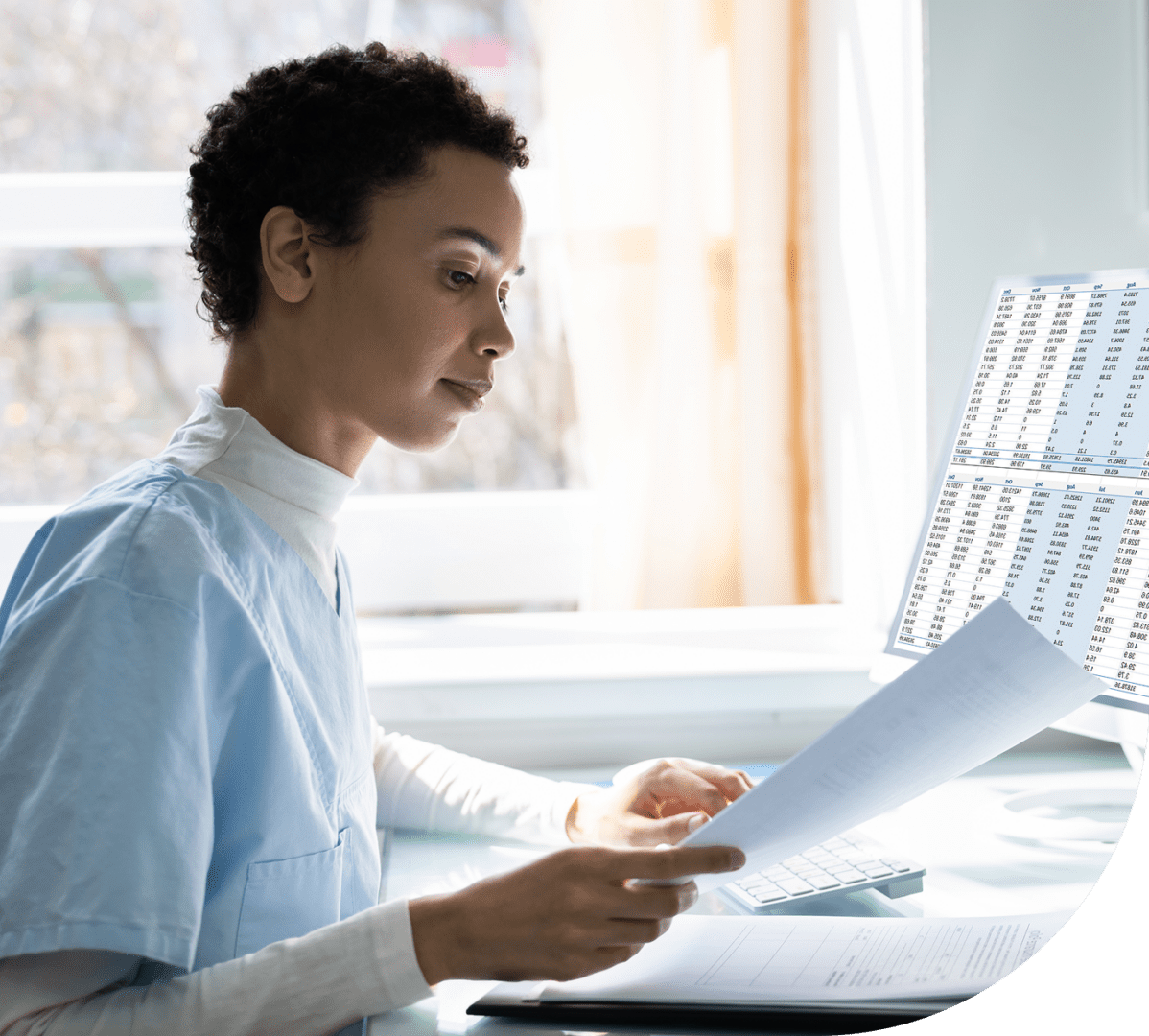Healthcare professional reviewing documents at desk